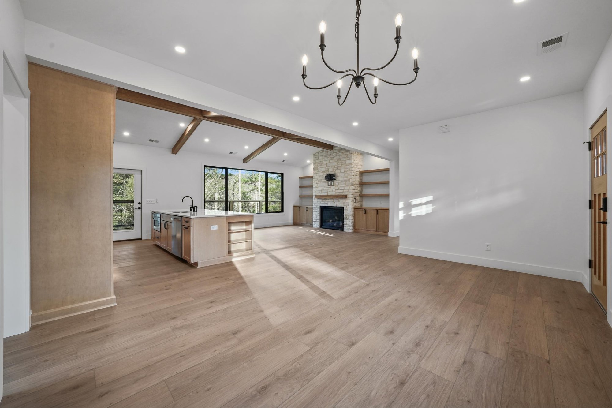 Wide view of main room, living room with stone fireplace, and large island near Knoxville, TN