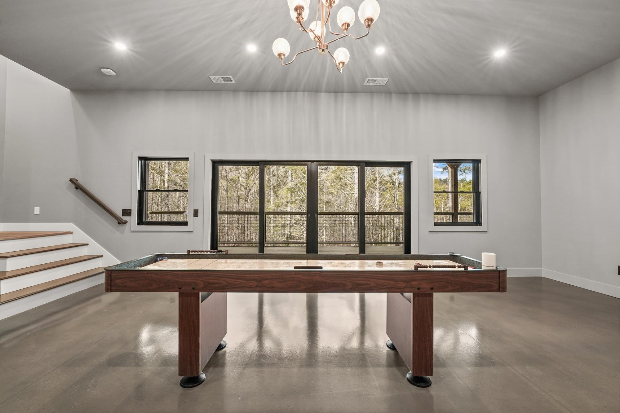 sunken living room with LVP flooring and chandelier lighting with pool table 1