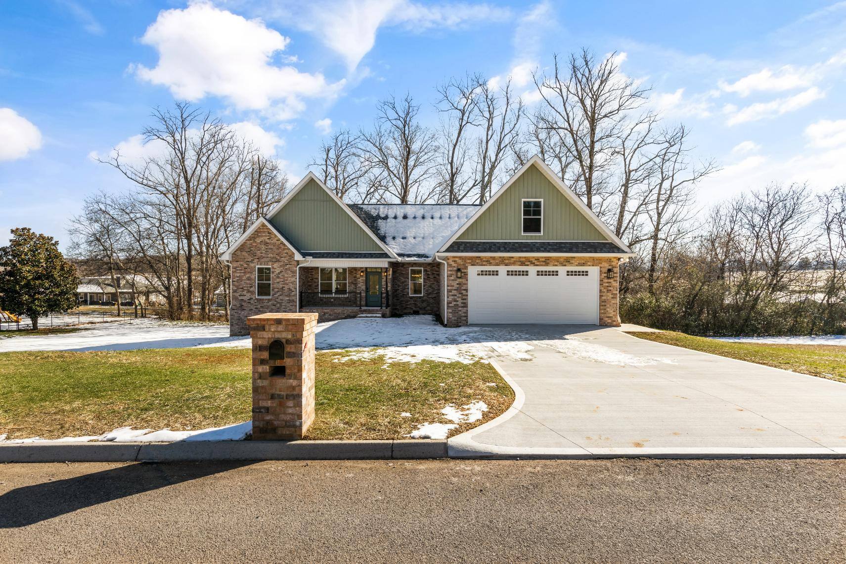 Custom home in Knoxville, TN by Debuty Builders, Inc., showing the spacious driveway, brick mailbox, and surrounding winter landscape