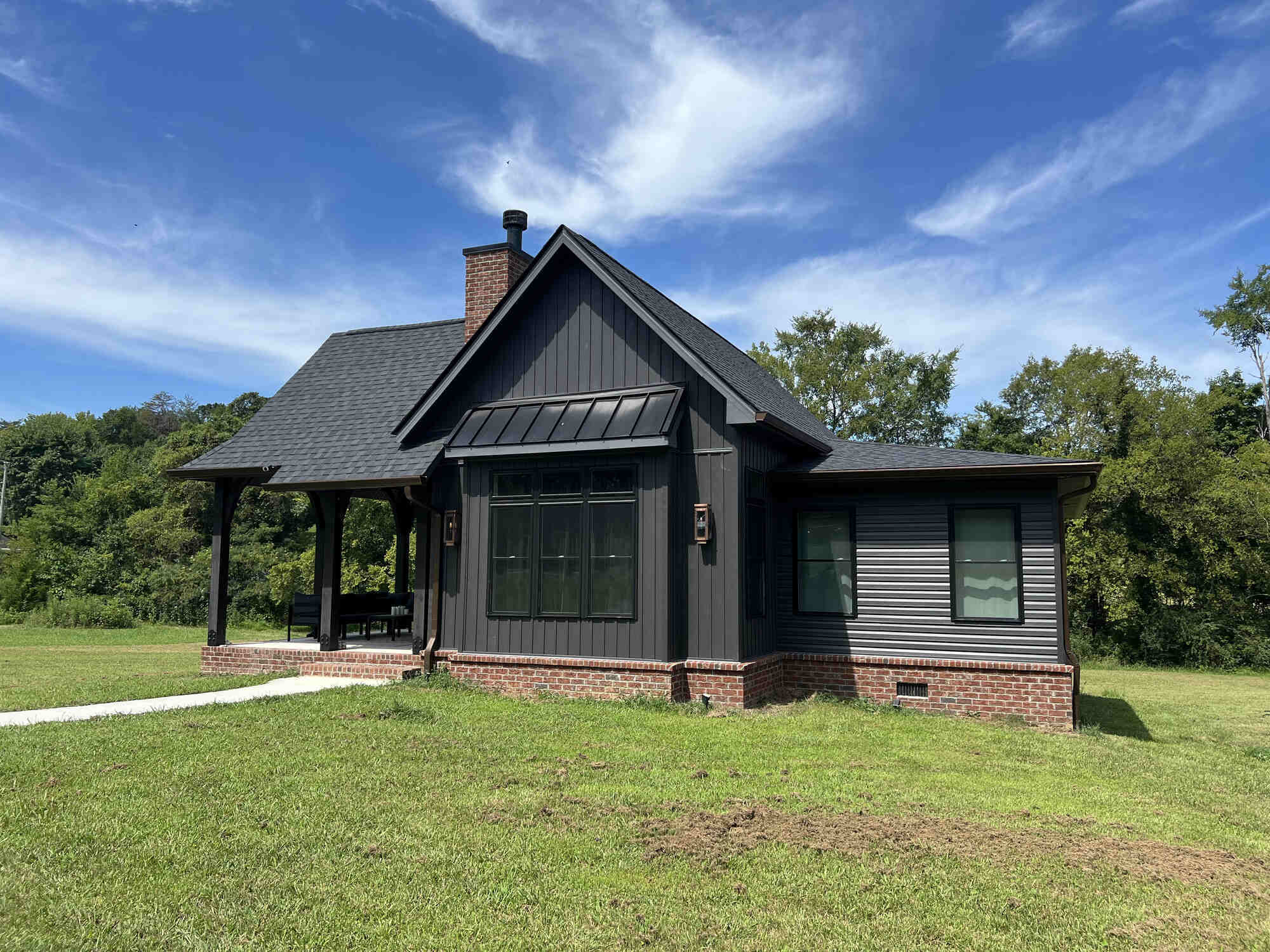 Exterior view of a custom home with dark siding and brick accents by Debuty Builders, Knoxville, TN