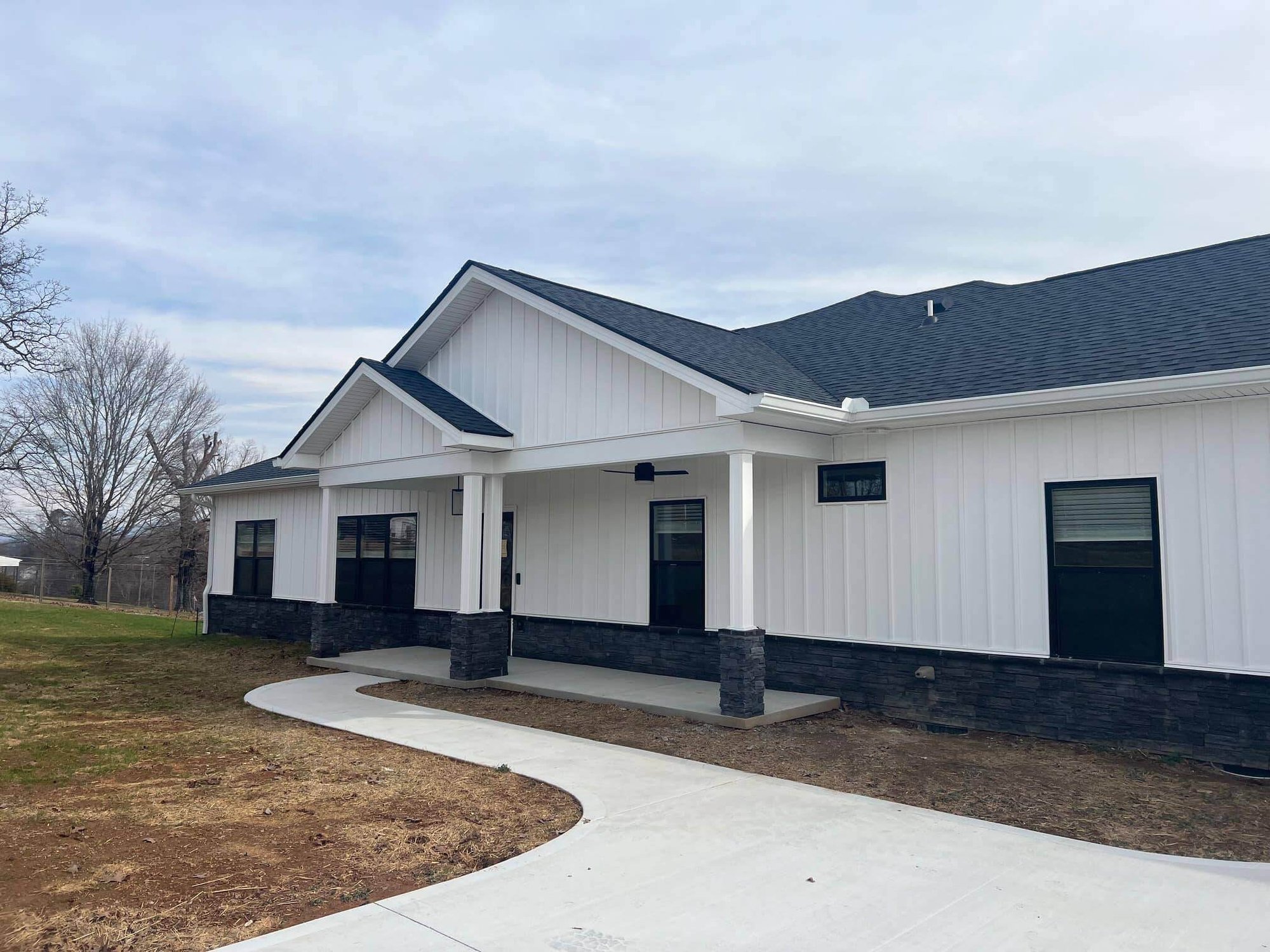Exterior of a modern farmhouse-style home with white siding by Debuty Builders in Knoxville, TN