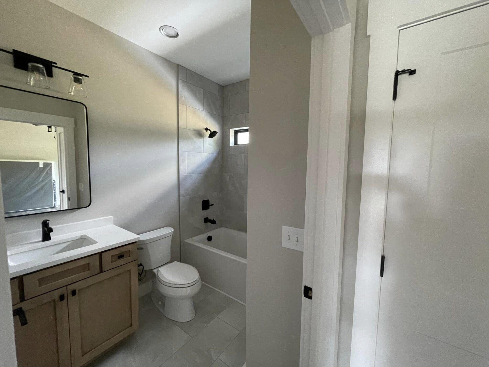 Minimalist bathroom design with tiled walls, a modern bathtub, and natural wood accents in Knoxville, TN