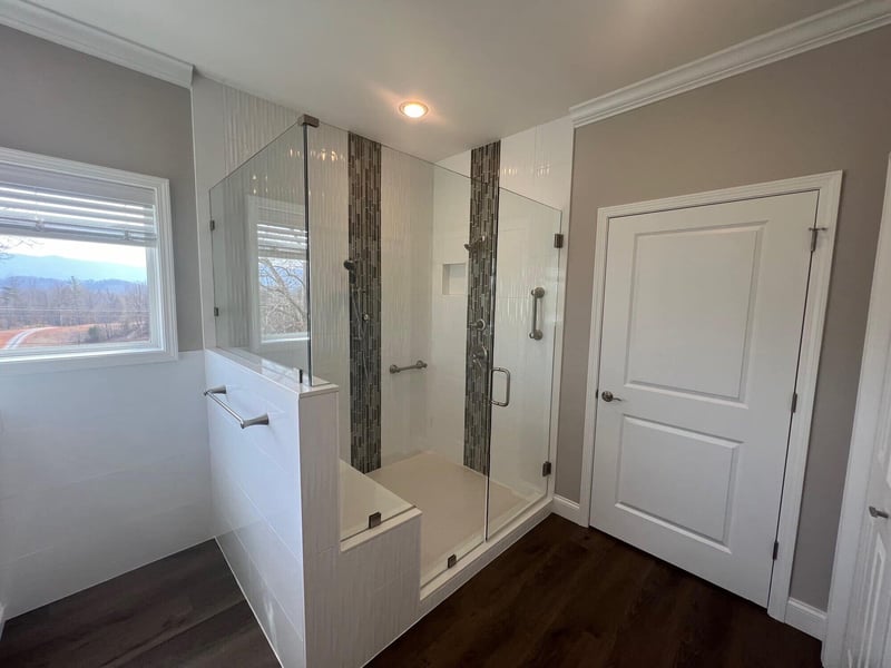 Walk-in shower with modern glass doors and scenic window views in a Knoxville, TN remodel by Debuty Builders