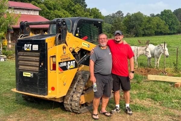 Debuty Builders team members standing next to a CAT machine at a farm renovation site in Knoxville, TN