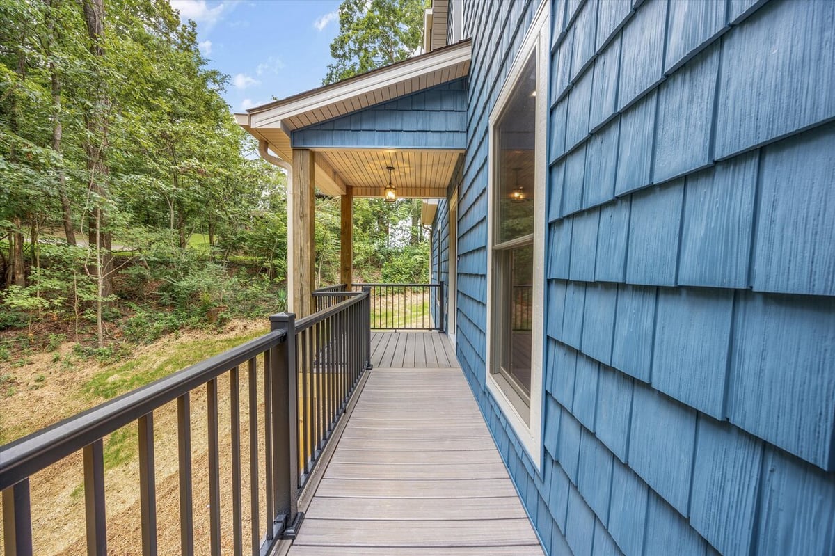 Rear deck with railing and elevated view of wooded property in Friendsville Custom Home in Knoxville, TN