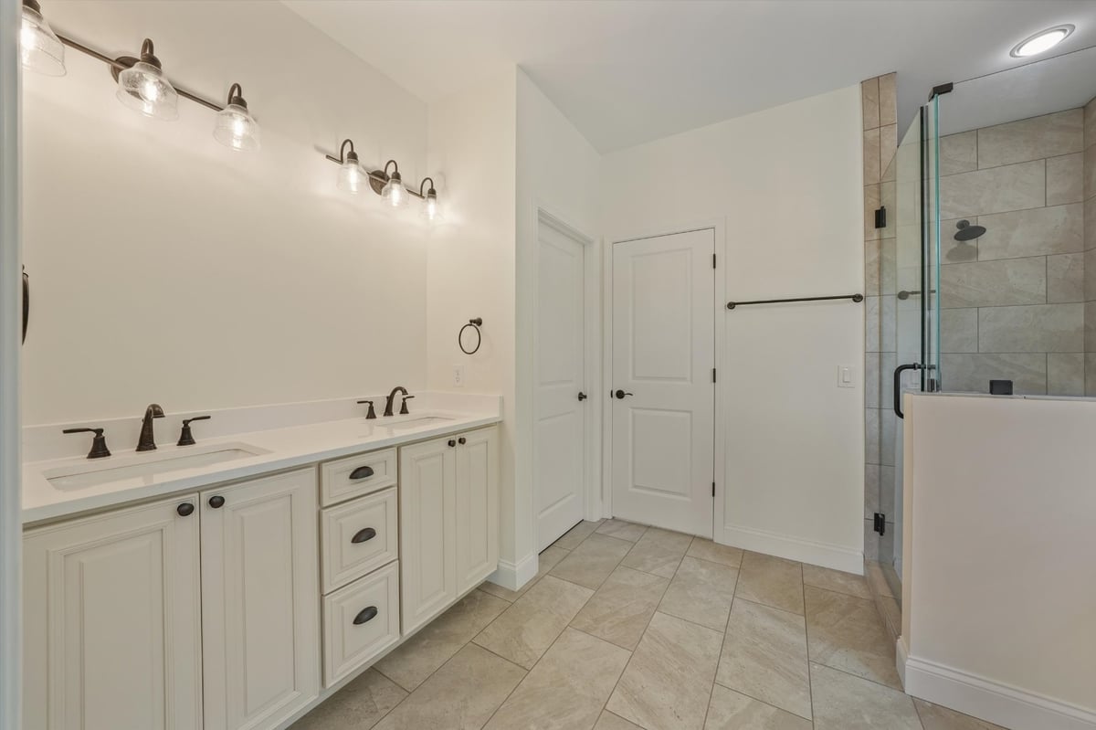 custom home bathroom with double vanity tiled floor and glass shower in maryville tn