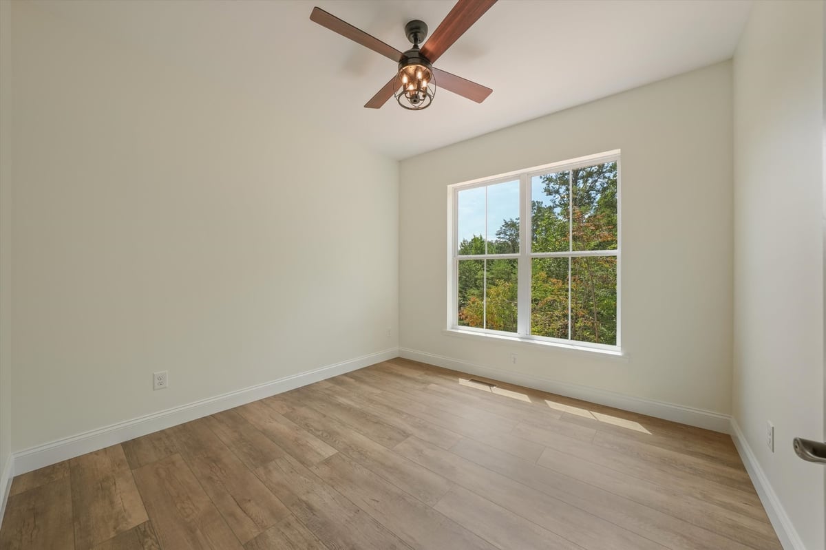custom home bedroom with large window and wood look flooring in maryville tn