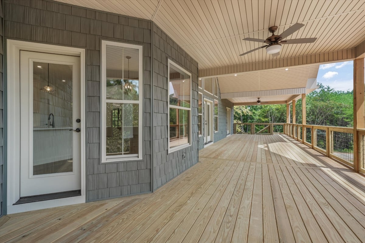 custom home covered deck with wood flooring ceiling fans and wooded views in maryville tn