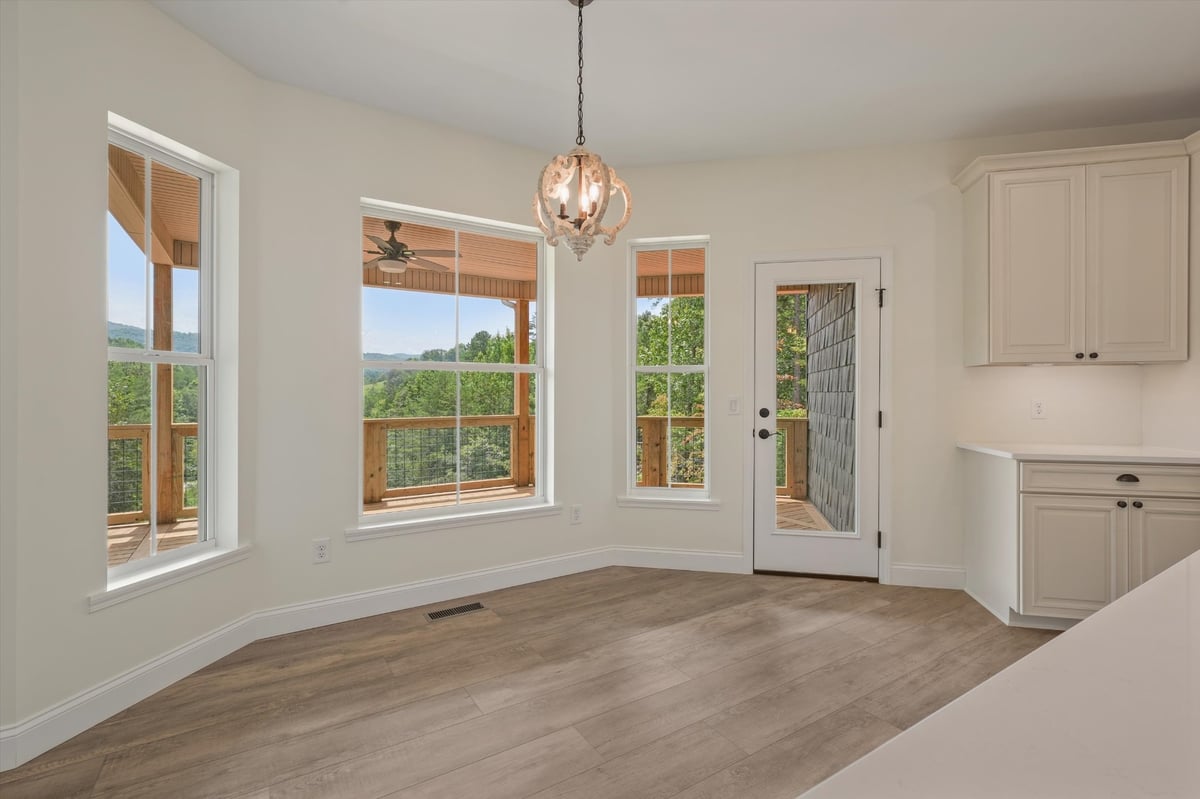 custom home dining area with large windows deck access and decorative pendant light in maryville tn