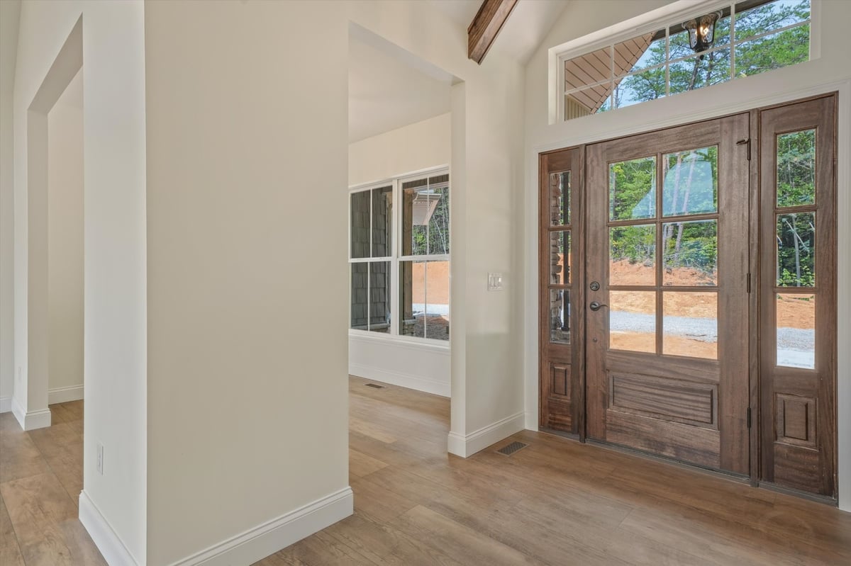 custom home foyer with wood glass front door and transom window in maryville tn