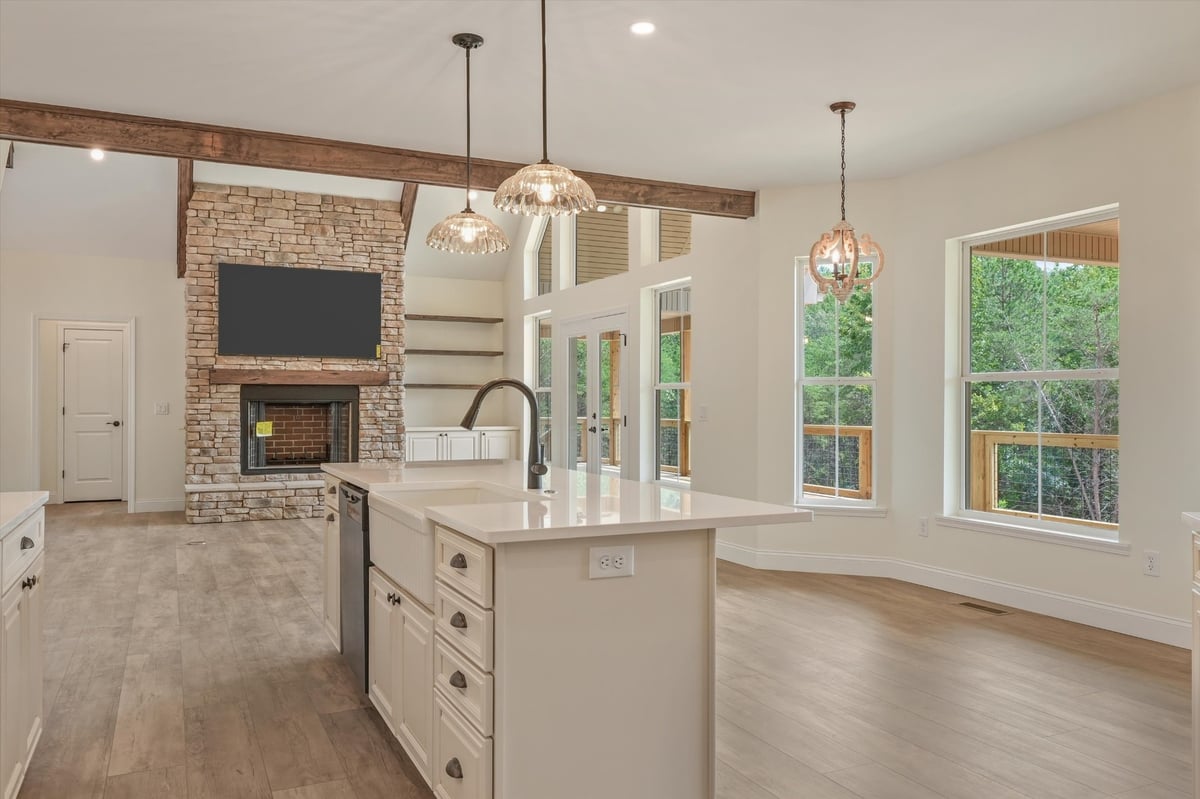 custom home kitchen island overlooking stone fireplace and tall windows in maryville tn