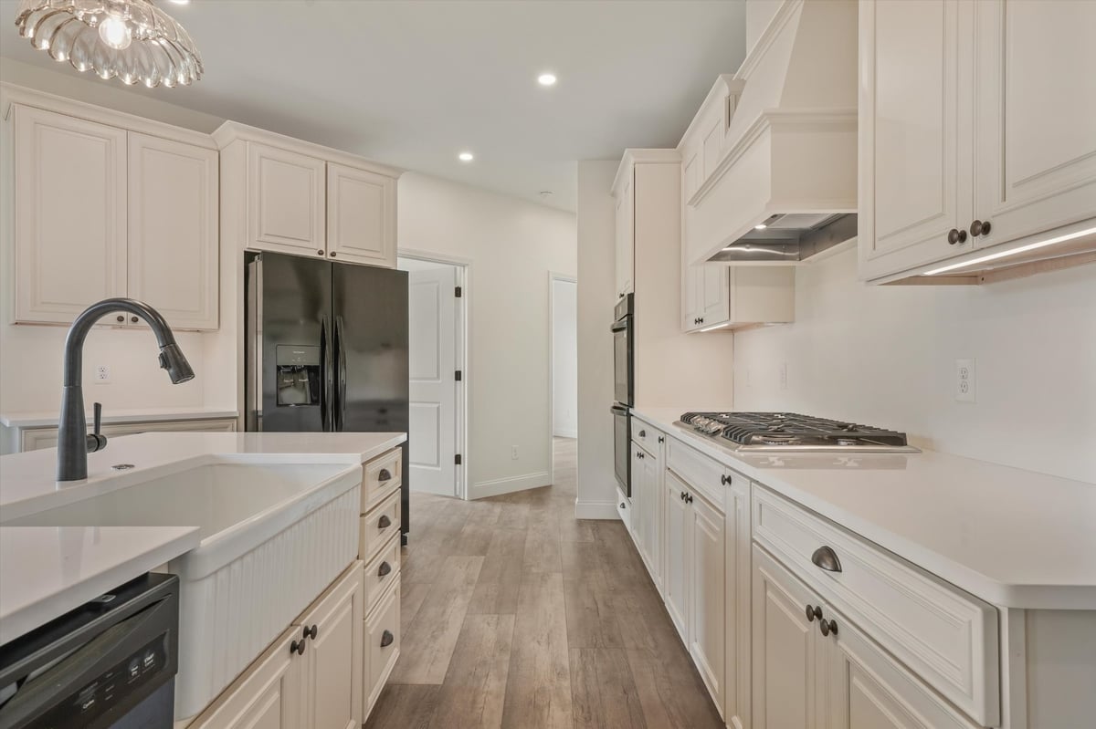custom home kitchen with farmhouse sink white cabinets gas cooktop and custom hood in maryville tn