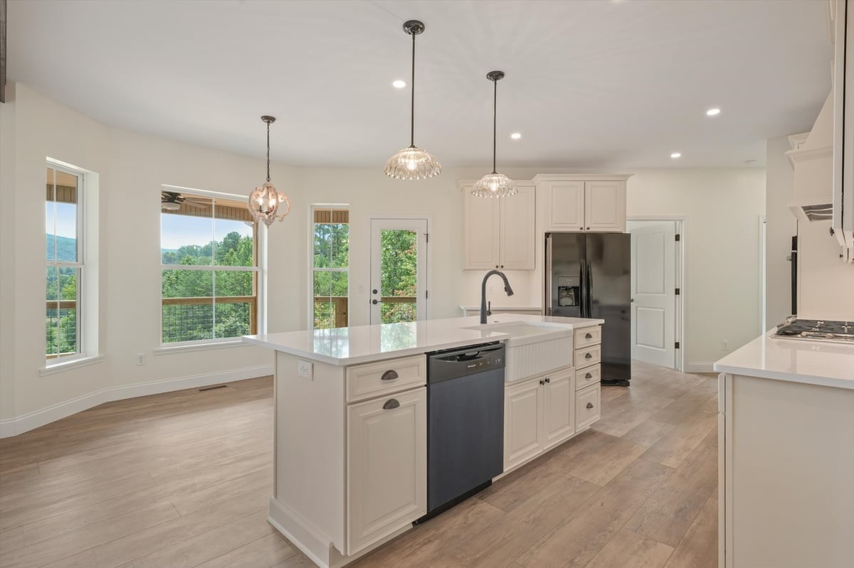 custom home kitchen with large white island farmhouse sink and pendant lights in maryville tn
