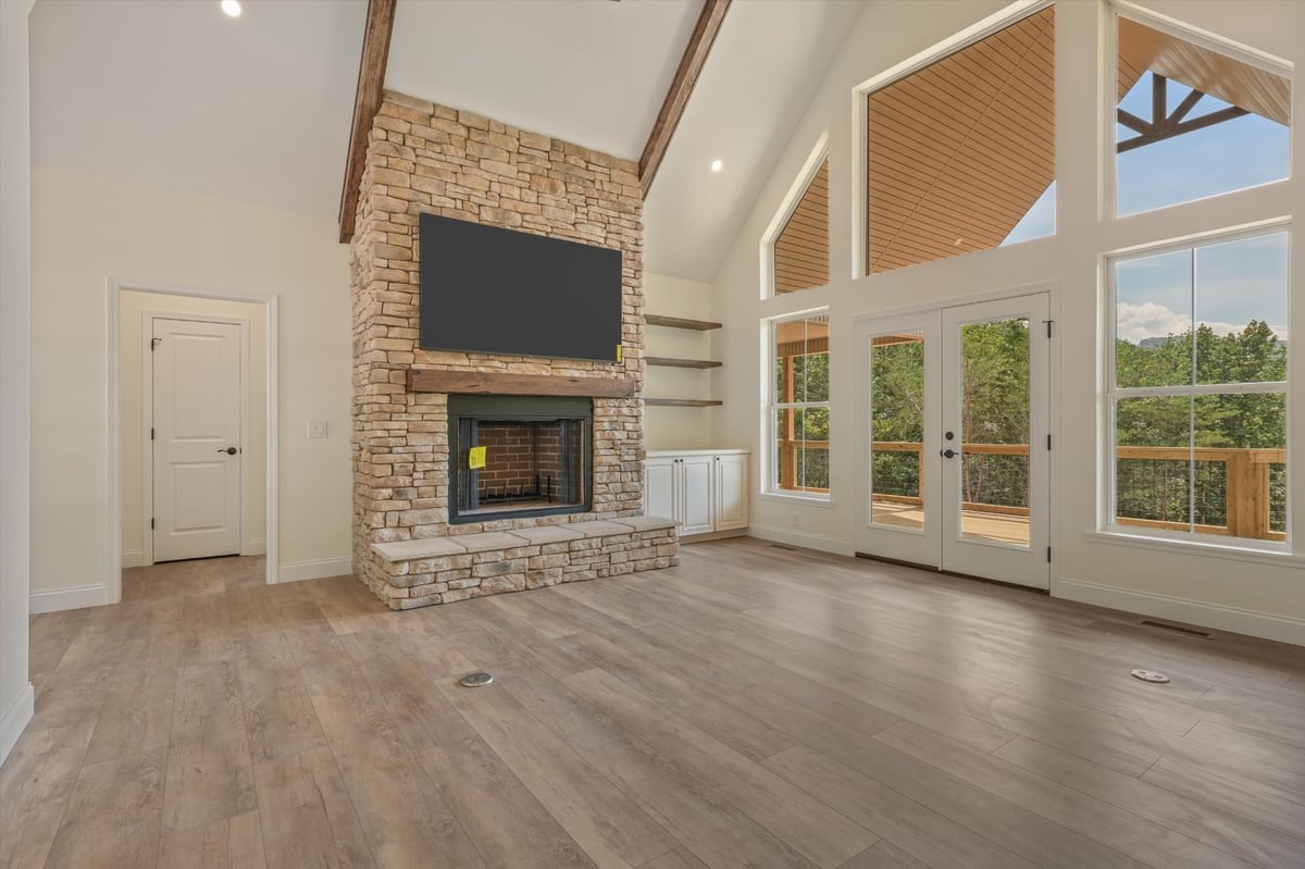 custom home living room with stone fireplace vaulted ceiling and tall windows in maryville tn