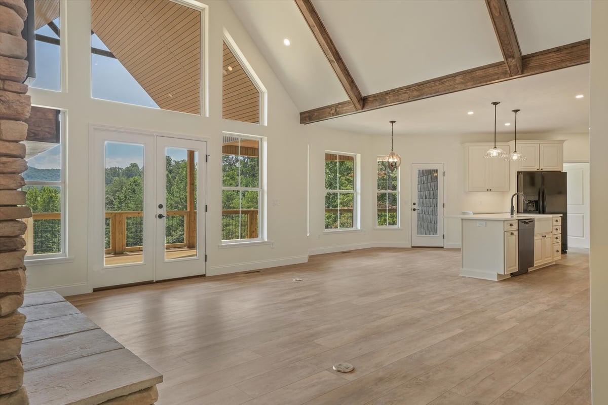 custom home open living and kitchen area with vaulted ceiling and exposed wood beams in maryville tn