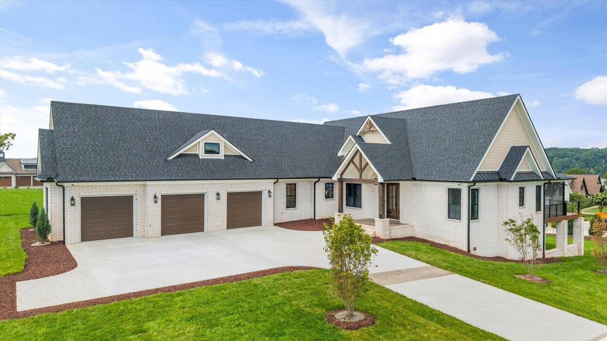 Aerial front angle of a Louisville, TN custom home with landscaped yard and dark shingle roofing
