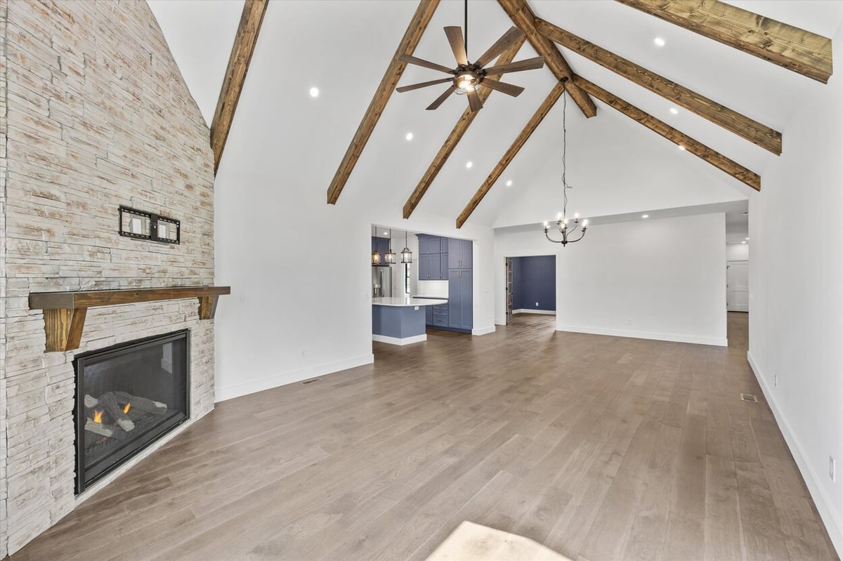 Angled interior view of a Louisville, TN custom home great room with vaulted ceiling and wood beam detail