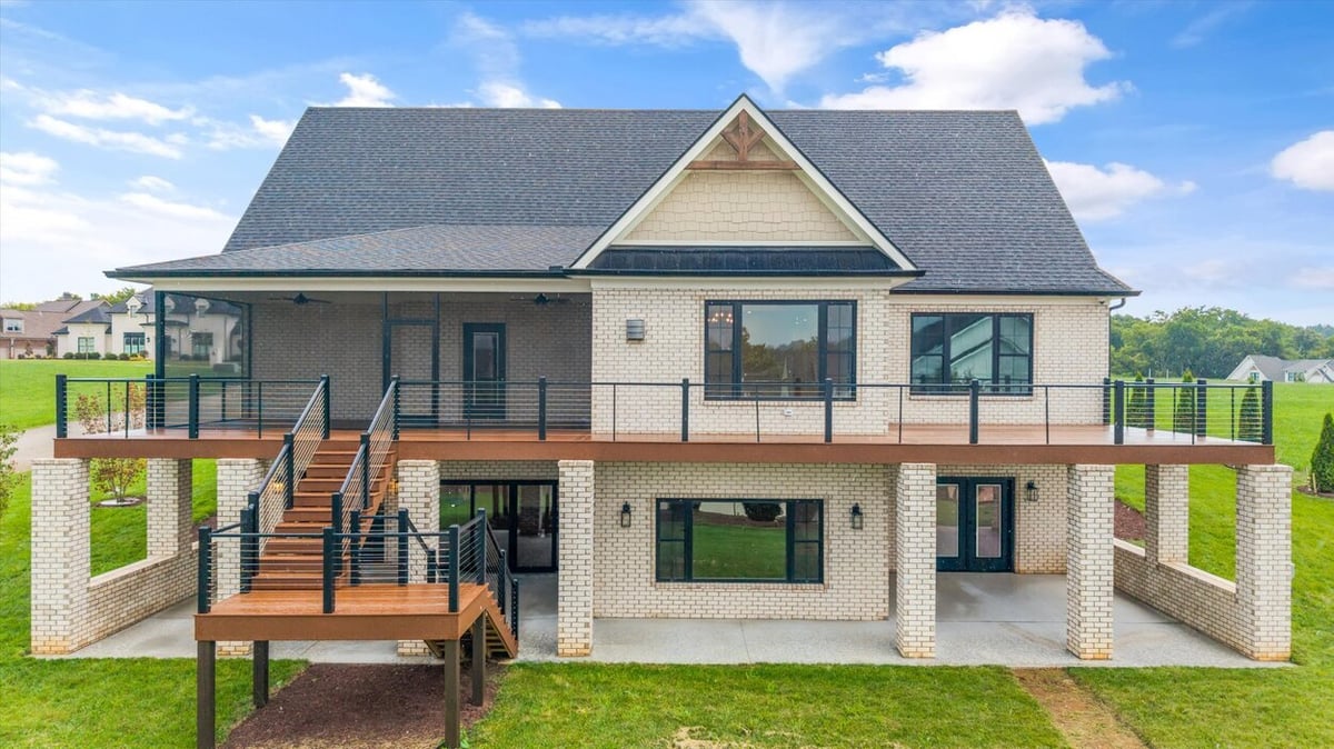 Back view of two-level brick home with wood staircase in Louisville, TN Custom Home