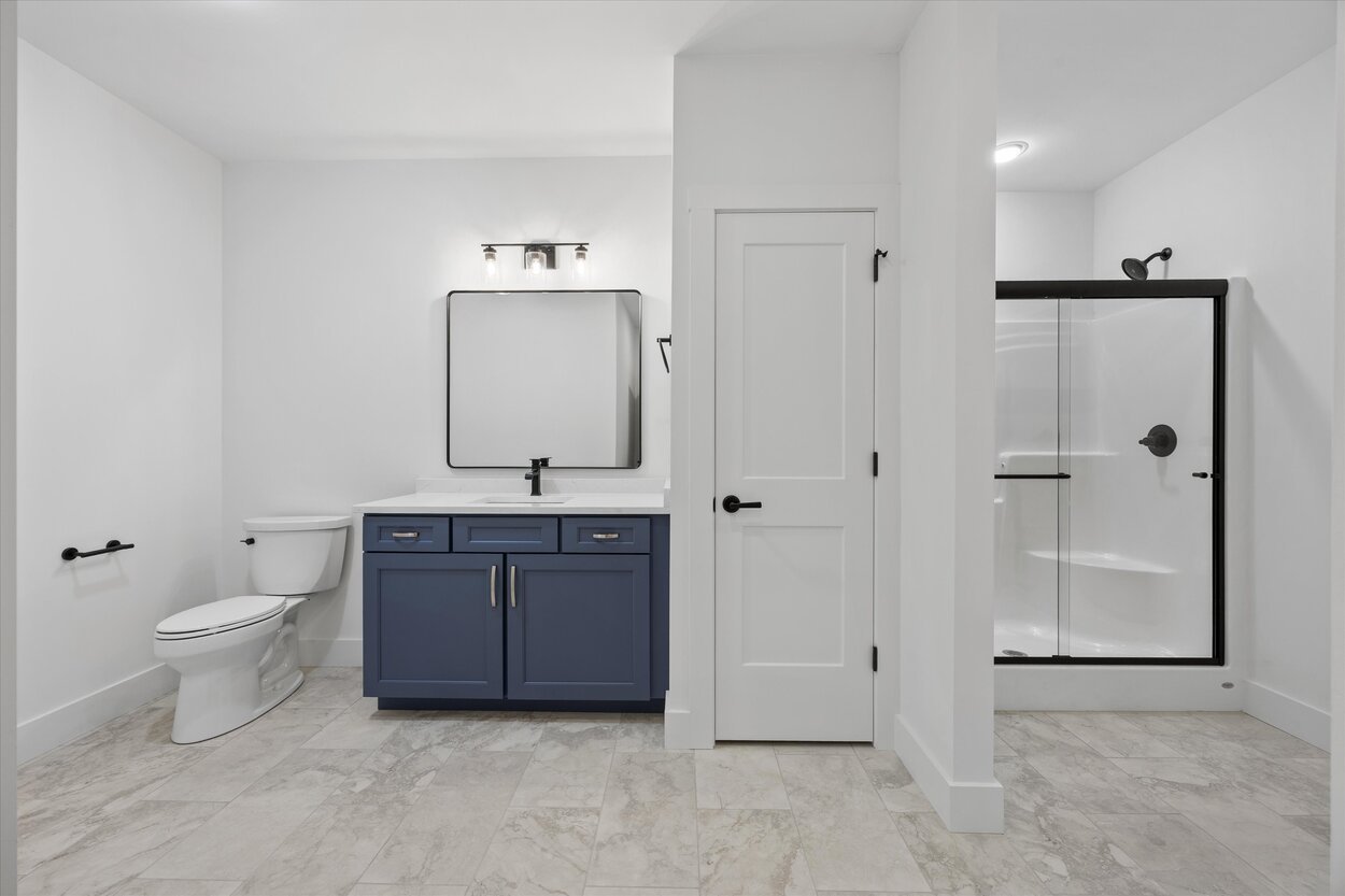 Basement bathroom in a Louisville, TN custom home with walk-in shower and navy vanity