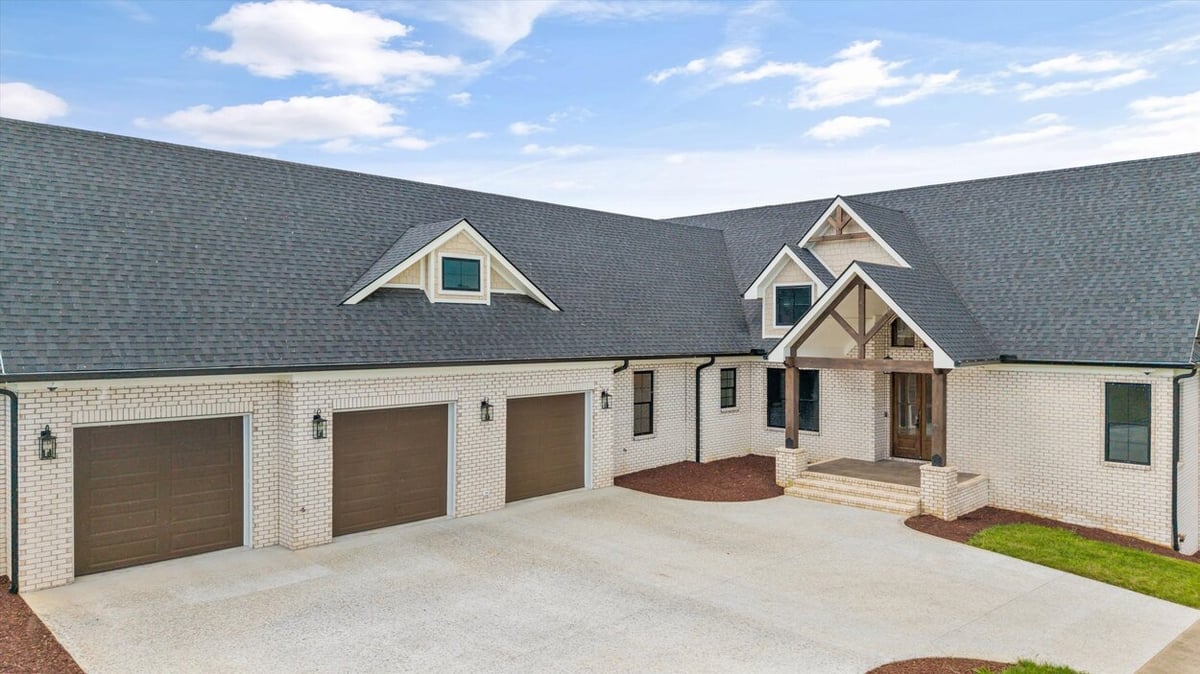 Detailed look at front elevation of a Louisville, TN custom home with timber-frame entry and white brick exterior