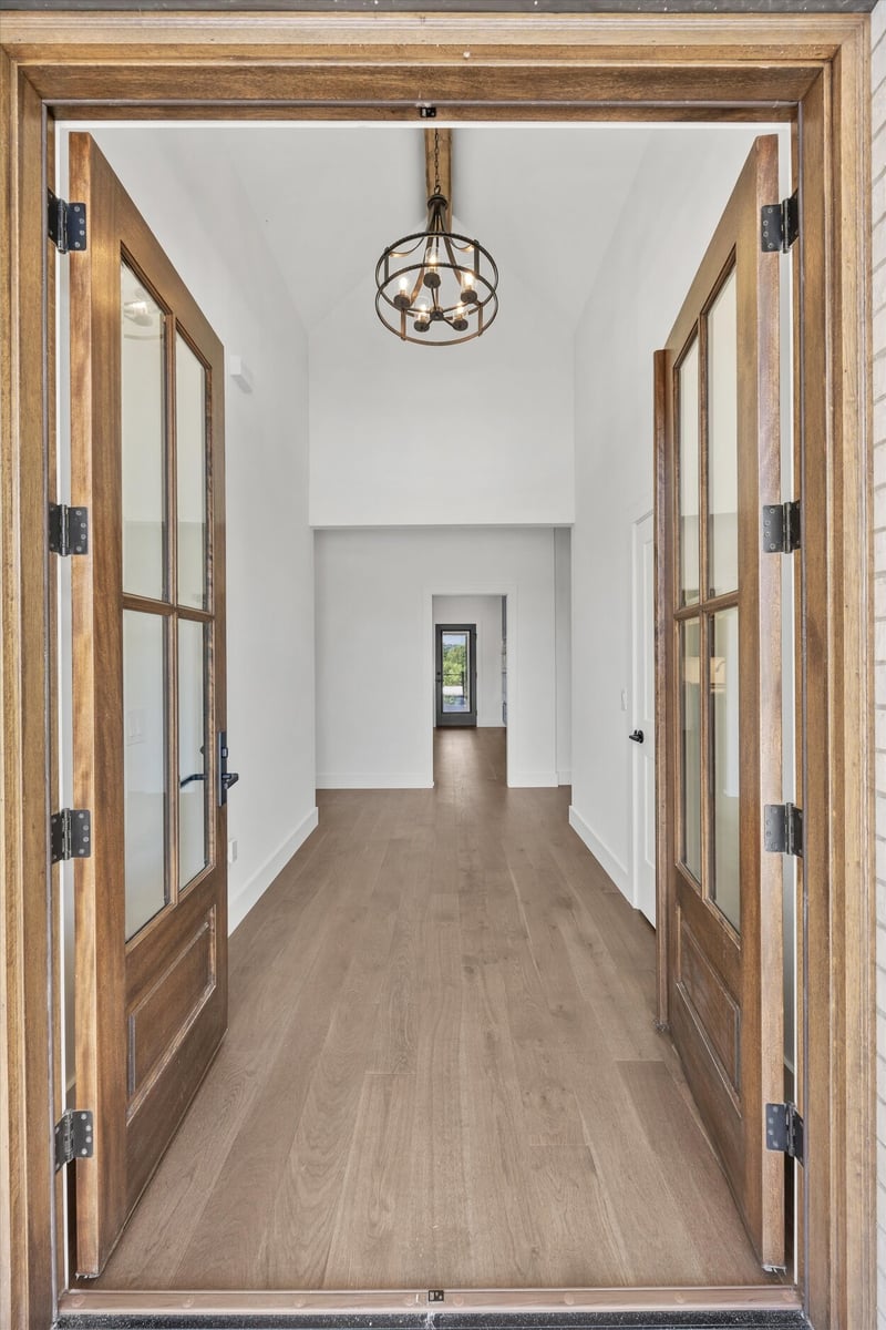 Entryway view in a Louisville, TN custom home with open French doors and wide-plank hardwood floors