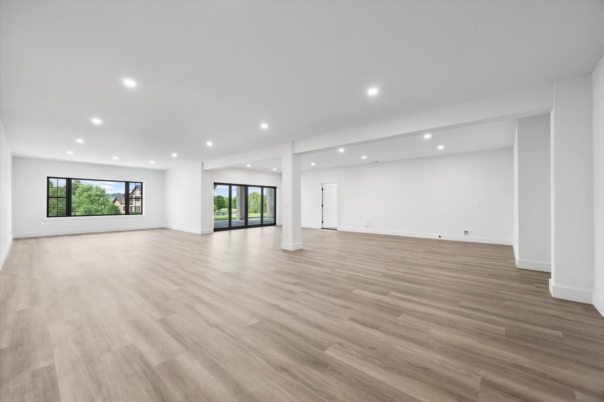 Expansive basement living space in a Louisville, TN custom home with recessed lighting and wood floors