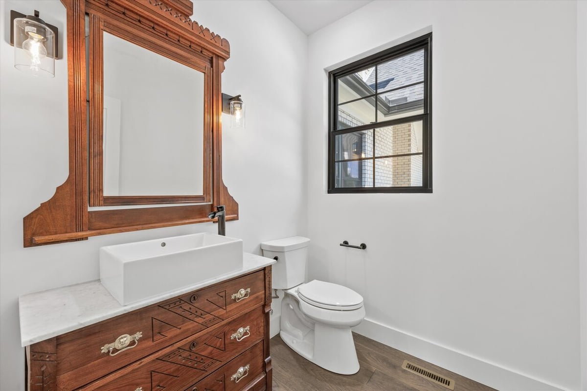 Half bath in a Louisville, TN custom home featuring a vintage dresser vanity and vessel sink