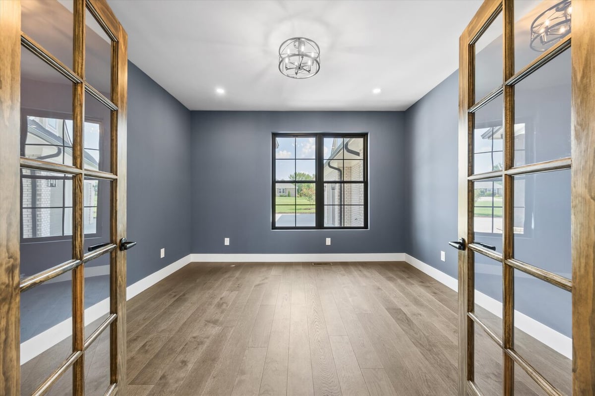 Home office in a Louisville, TN custom home with blue walls, French doors, and wide-plank flooring