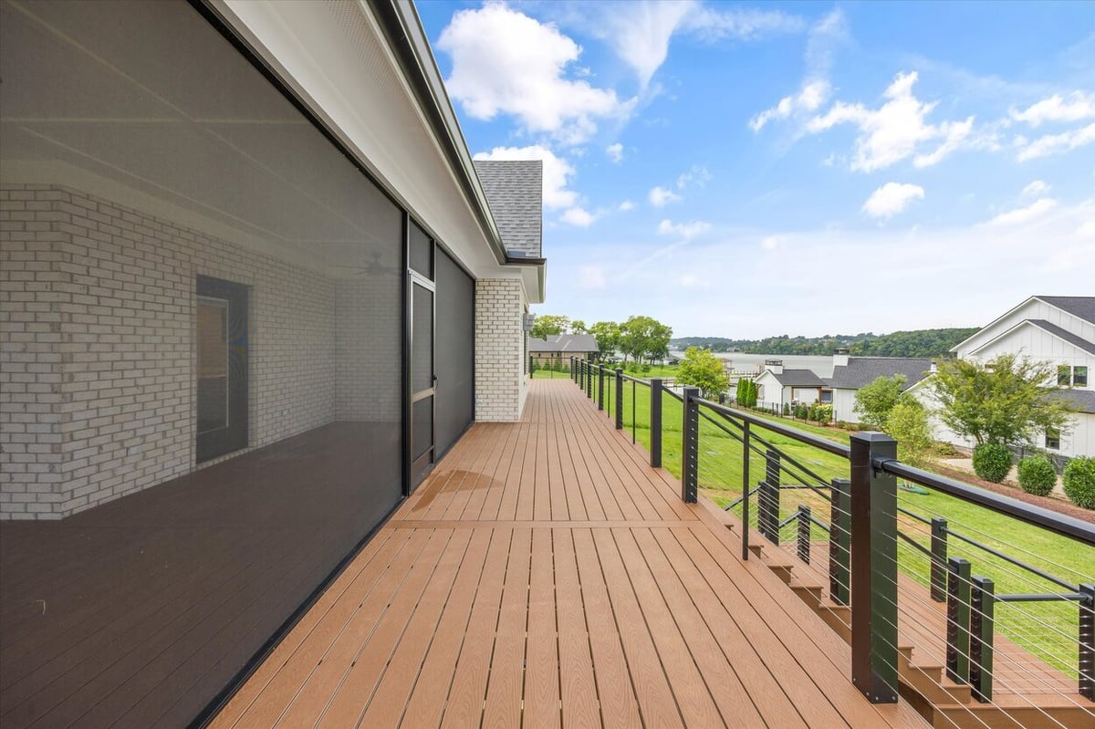 Long deck walkway in a Louisville, TN custom home with black cable railing and screen room exterior