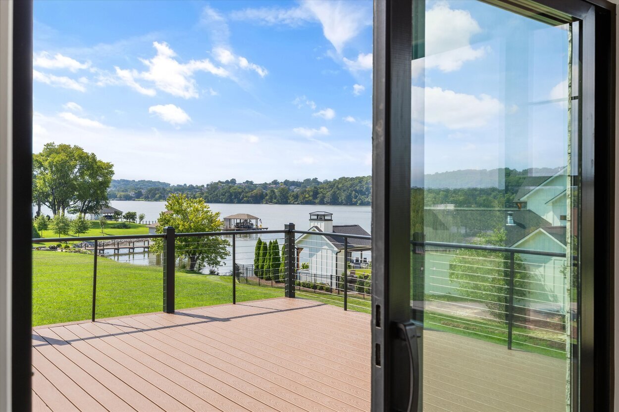 Scenic lake view from the deck of a Louisville, TN custom home with cable railing and manicured lawn