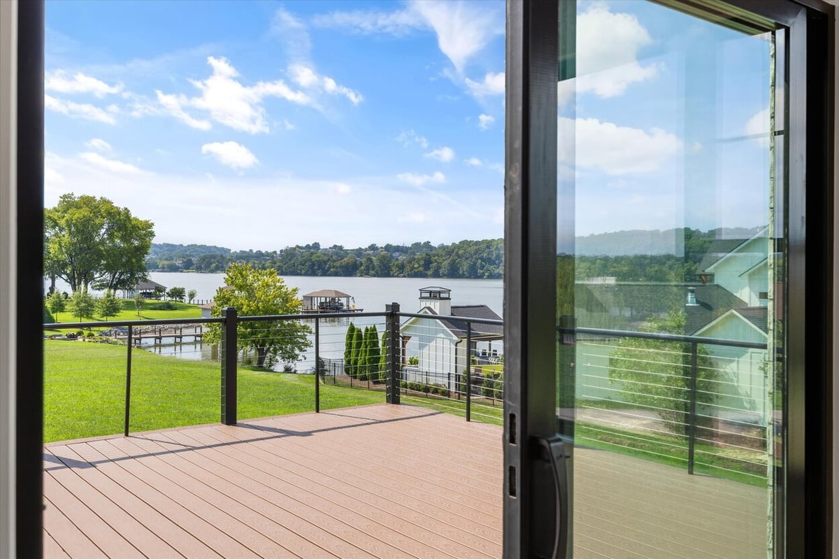 Scenic lake view from the deck of a Louisville, TN custom home with cable railing and manicured lawn