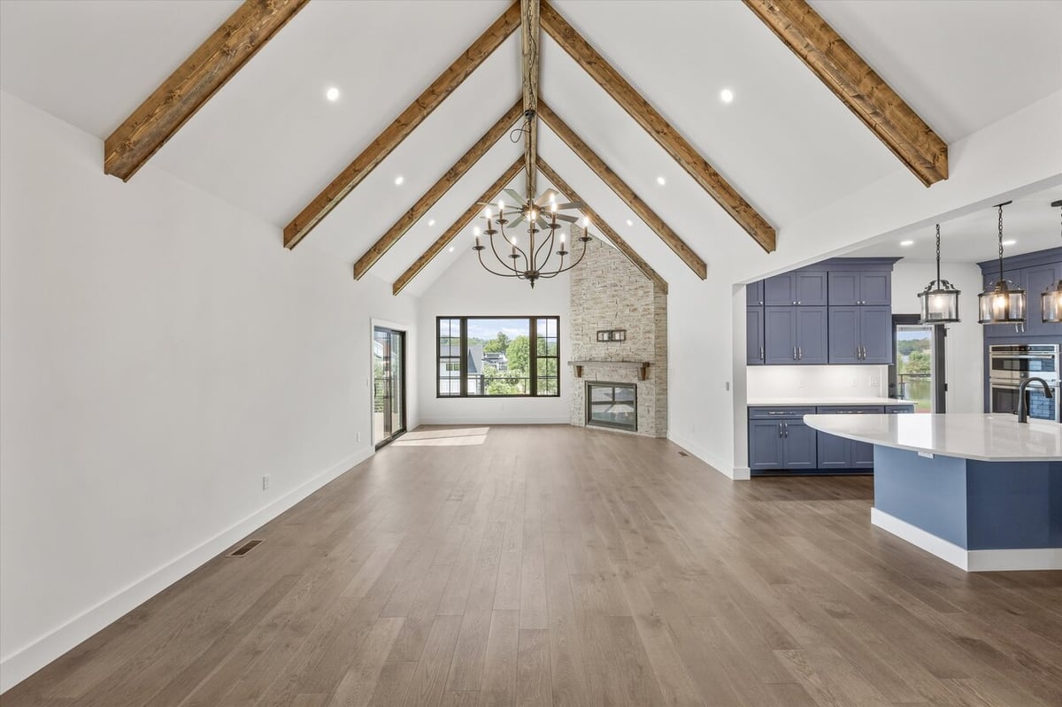 Vaulted ceiling great room in a Louisville, TN custom home featuring exposed beams and large windows