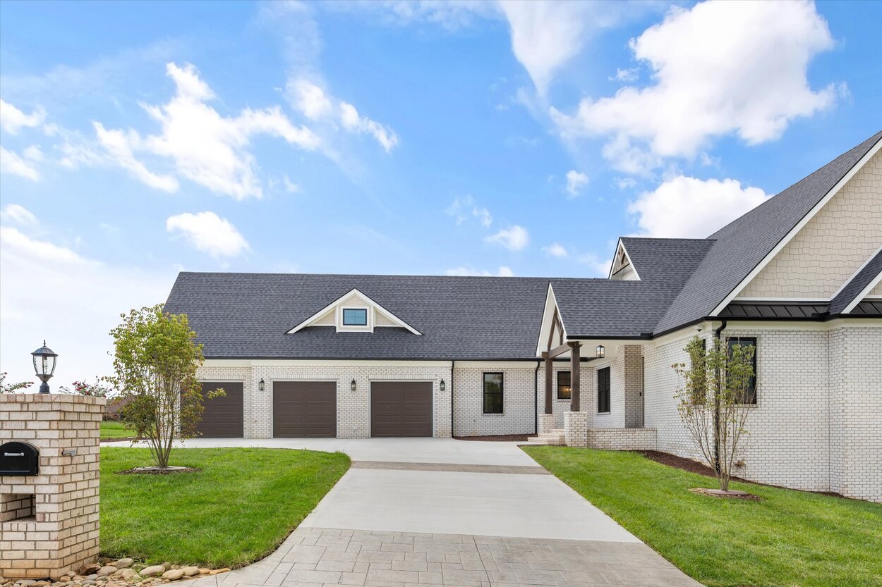View of the driveway and lawn leading to a Louisville, TN custom home with charming gables