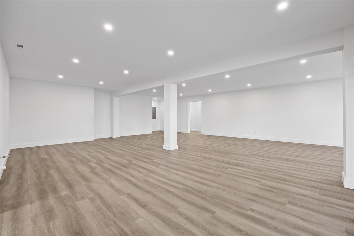 Wide view of basement interior in a Louisville, TN custom home with white walls and column details