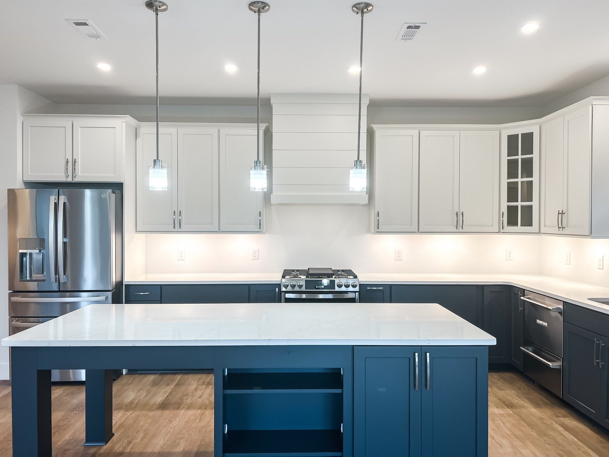 Open kitchen layout in a custom home by Debuty Builders, Inc. in Maryville, TN, with a large island, pendant lights, and a windowed dining area