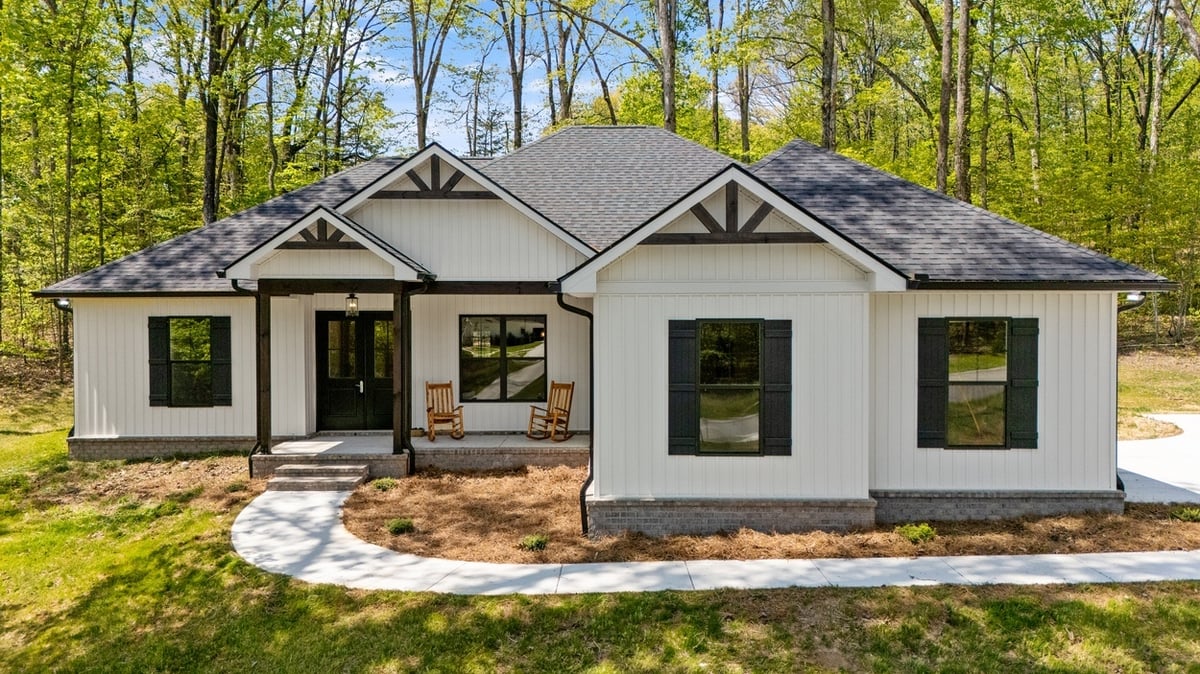 White farmhouse with black trim set in wooded lot in Vonore custom home in Knoxville, TN
