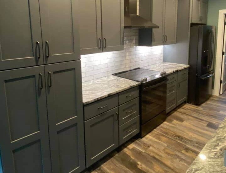 Sleek kitchen featuring granite countertops and gray cabinetry in Knoxville custom home by Debuty Builders