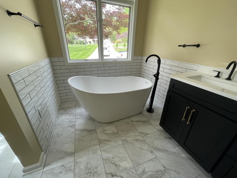 Freestanding bathtub with white subway tile walls, part of a bathroom remodel by Debuty Builders in Knoxville, TN