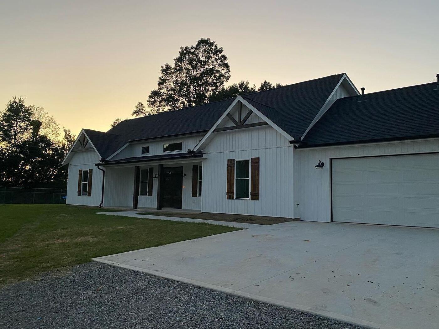 A modern white custom home by Debuty Builders in Knoxville, TN, at sunset, with a clean, minimalist design